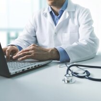 online medical consultation - doctor working on laptop computer in clinic office. copy space